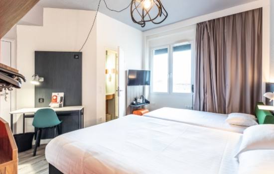 un lit simple et un lit double dans une chambre d'hotel